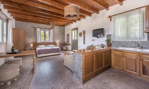 een keuken met een wastafel en een bed in een kamer bij Sophia's Ralaki Cottage in Ralaki