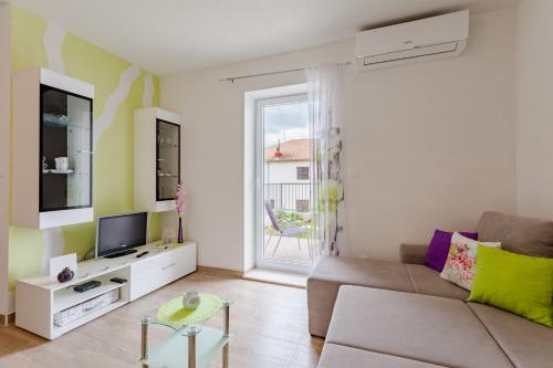 a living room with a couch and a tv at Apartment Anamaris in Solin