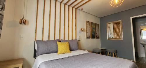 Hotel Voila la Moneda في سانتياغو: غرفة نوم بسرير ومخدة صفراء