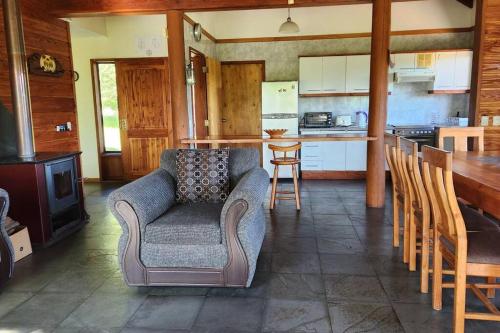 a living room with a couch and a kitchen at Casa con acceso privado al río in Villarrica