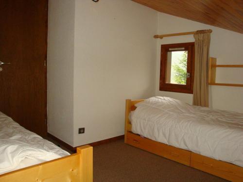 une chambre avec deux lits et une fenêtre dans l'établissement Duplex ensoleillé avec piscine chauffée, proche centre et pistes - FR-1-464-34, à Pralognan-la-Vanoise