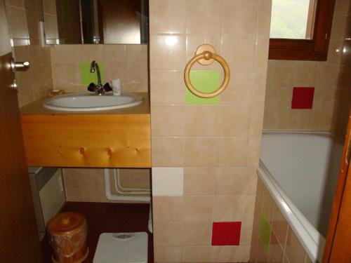 une petite salle de bain avec un lavabo et une baignoire dans l'établissement Duplex ensoleillé avec piscine chauffée, proche centre et pistes - FR-1-464-34, à Pralognan-la-Vanoise