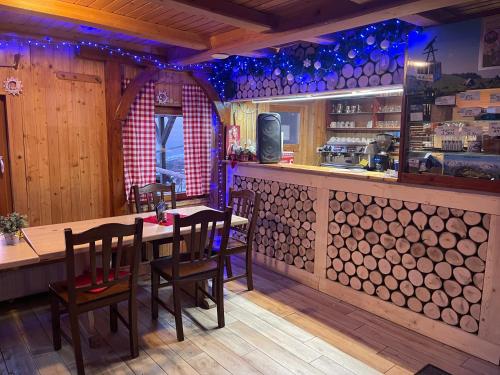 een restaurant met een tafel en stoelen en een bar bij Velika planina Chalet SLOVENKA in Stahovica
