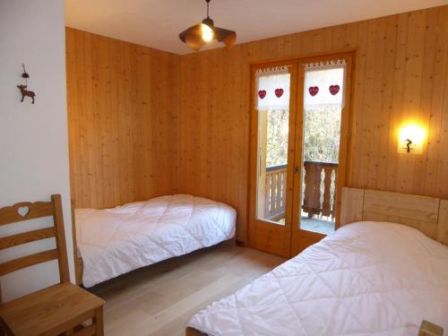 - 2 lits dans une chambre dotée de murs en bois et de fenêtres dans l'établissement Chalet spacieux avec terrasse, proche commerces et télécabine, garage et parking inclus - FR-1-464-37, à Champagny-en-Vanoise