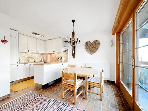 eine Küche mit einem Tisch, Stühlen und einer Herzwand in der Unterkunft Our little marmots' dream in Bruson