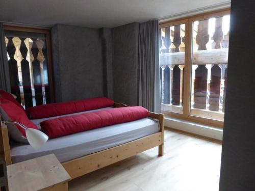 貝爾金的住宿－Biala - BioBergün，靠窗的沙发,配有红色枕头