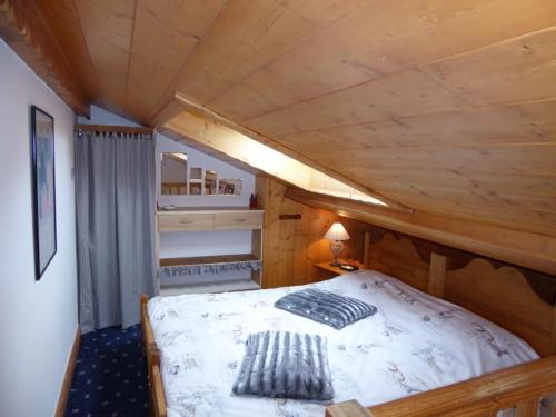 une chambre avec un lit dans une cabane en bois dans l'établissement Charmant Duplex Mezzanine avec Balcon près des Pistes, Pralognan-la-Vanoise - FR-1-464-43, à Pralognan-la-Vanoise