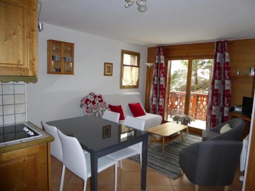 une cuisine et un salon avec une table et des chaises dans l'établissement Rez-de-jardin cosy avec 3 pièces, proche pistes et centre de Pralognan-la-Vanoise - FR-1-464-55, à Pralognan-la-Vanoise