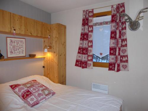 - une chambre avec un lit et une fenêtre avec des rideaux rouges dans l'établissement Appartement Pralognan-la-Vanoise, 3 pièces, 6 personnes - FR-1-464-52, à Pralognan-la-Vanoise