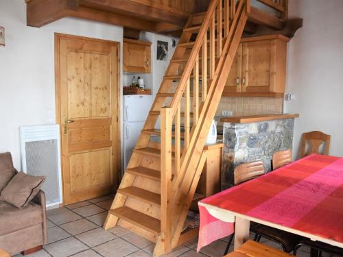 - un escalier en bois dans une cuisine avec une table dans l'établissement Duplex Confortable à Pralognan-la-Vanoise avec Wifi et Terrasse Sud, à 400m des Commerces - FR-1-464-56, à Pralognan-la-Vanoise