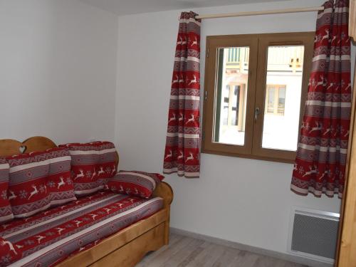 プラローニャン・ラ・ヴァノワーズにあるAppartement Pralognan-la-Vanoise, 4 pièces, 8 personnes - FR-1-464-58の赤いカーテンと窓付きのベッドが備わる客室です。