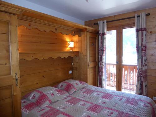 プラローニャン・ラ・ヴァノワーズにあるAppartement Pralognan-la-Vanoise, 3 pièces, 6 personnes - FR-1-464-59の木製の壁のベッドルーム1室(ベッド1台付)