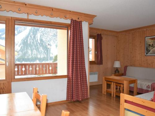 un salon avec une grande fenêtre et une table dans l'établissement Appartement Chaleureux avec Balcon Sud à 600m du Centre et Proche des Pistes, Pralognan-la-Vanoise - FR-1-464-62, à Pralognan-la-Vanoise