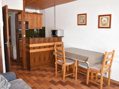 une cuisine avec une table et des chaises dans une pièce dans l'établissement Confortable Studio avec Balcon Sud, Pied des Pistes, 4 Personnes, Pralognan-la-Vanoise - FR-1-464-71, à Pralognan-la-Vanoise
