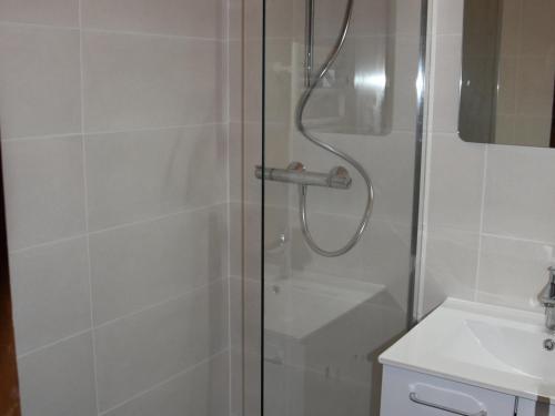 une douche avec une porte vitrée à côté d'un lavabo dans l'établissement Confortable Studio avec Balcon Sud, Pied des Pistes, 4 Personnes, Pralognan-la-Vanoise - FR-1-464-71, à Pralognan-la-Vanoise