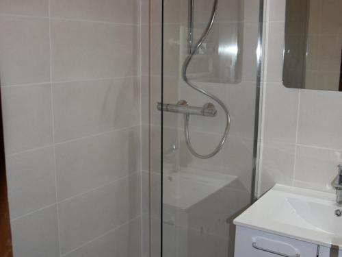 a shower with a glass door next to a sink at Studio Pralognan-la-Vanoise, 1 pièce, 4 personnes - FR-1-464-71 in Pralognan-la-Vanoise