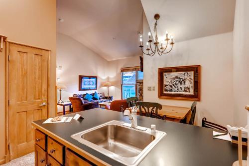 a kitchen with a sink and a living room at Jackpine & Black Bear Condominiums by Keystone Resort in Keystone