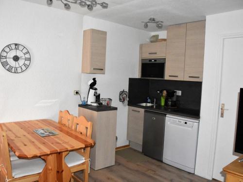 une cuisine avec une table en bois et une cuisine avec une salle à manger dans l'établissement Charmant 2 pièces avec terrasse, proche commerces et téléphérique, Pralognan-la-Vanoise - FR-1-464-92, à Pralognan-la-Vanoise