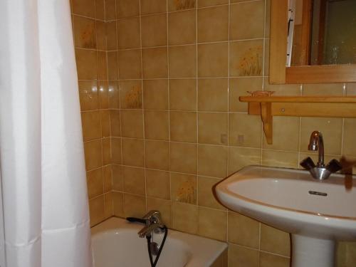 une salle de bain avec un lavabo et une baignoire dans l'établissement Charmant duplex lumineux avec parking couvert proche téléphérique - FR-1-464-95, à Champagny-en-Vanoise
