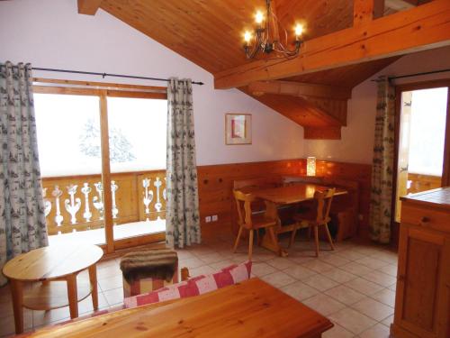 une salle à manger avec une table, des chaises et des fenêtres dans l'établissement Charmant appart 3 pièces dernier étage, balcon sud, parking, près pistes à Pralognan - FR-1-464-106, à Pralognan-la-Vanoise