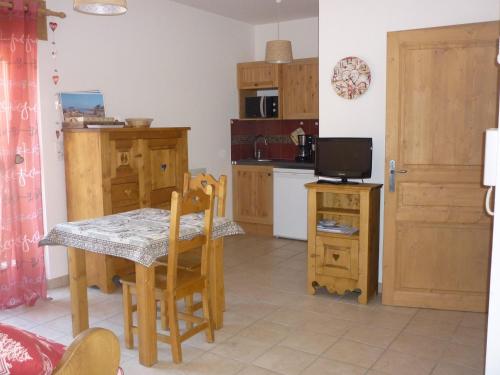 une cuisine avec une table et une petite cuisine avec une télévision dans l'établissement Studio cosy pour 2 - balcon, proche centre et téléphérique, animaux admis - FR-1-464-135, à Pralognan-la-Vanoise