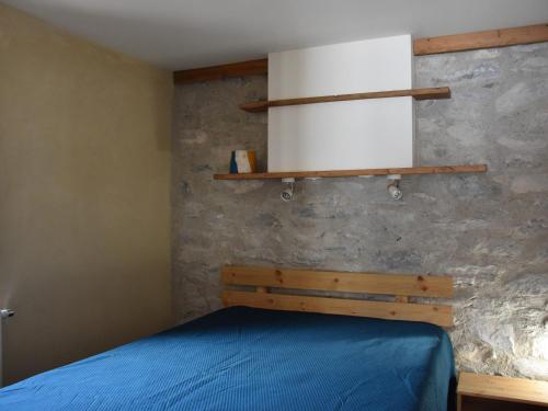- une chambre avec un lit bleu et une étagère dans l'établissement Charmant T2 avec terrasse, quartier calme, proche commerces et téléphérique - FR-1-464-142, à Pralognan-la-Vanoise