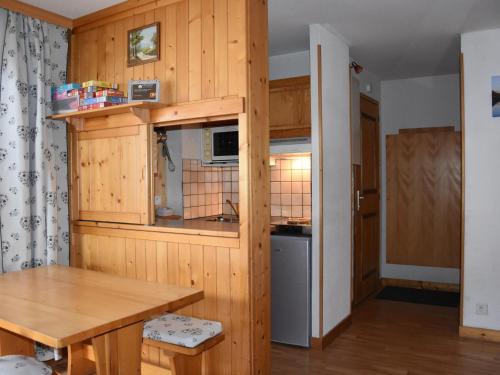 - une cuisine avec des murs en bois et une table en bois dans l'établissement Charmant 2 Pièces au Centre de Pralognan-la-Vanoise, Proche Téléphérique et Commerces - FR-1-464-89, à Pralognan-la-Vanoise