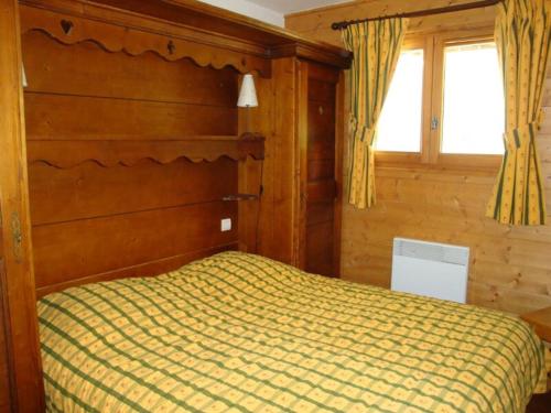 プラローニャン・ラ・ヴァノワーズにあるAppartement Pralognan-la-Vanoise, 3 pièces, 4 personnes - FR-1-464-111のベッドルーム1室(木製ヘッドボードと窓付)