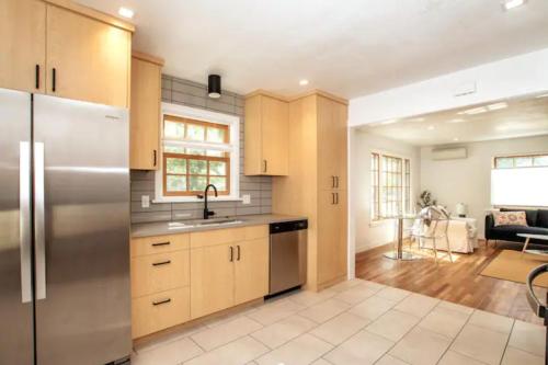 a kitchen with a stainless steel refrigerator and a living room at North End Bungalow in Boise