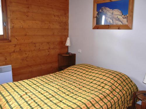 een slaapkamer met een bed en een spiegel aan de muur bij Appartement Pralognan-la-Vanoise, 3 pièces, 4 personnes - FR-1-464-127 in Pralognan-la-Vanoise