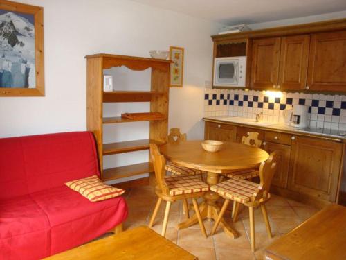 une petite cuisine avec une table et un canapé rouge dans l'établissement Charmant apt 3 pièces, balcon, proche pistes - FR-1-464-127, à Pralognan-la-Vanoise