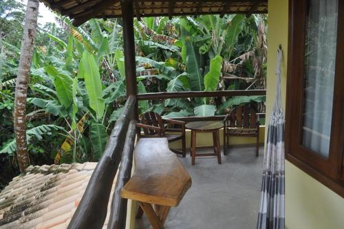 a porch with a swing and a table and chairs at Villa Cayana in Barra Grande
