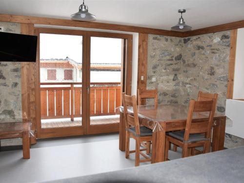 une salle à manger avec une table et des chaises et un balcon dans l'établissement Beau 2 pièces neuf, balcon sud, proche pistes et commerces, parking inclus - FR-1-464-141, à Pralognan-la-Vanoise