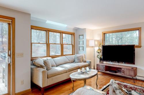 a living room with a couch and a flat screen tv at Tranquil Getaway in Wellfleet
