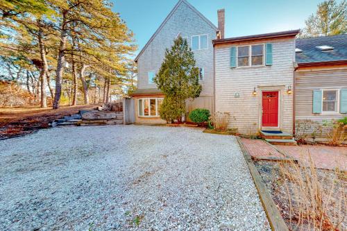 a house with a red door and a driveway at Tranquil Getaway in Wellfleet
