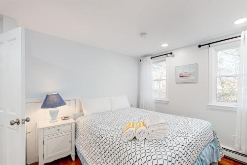a bedroom with a bed with two pairs of shoes on it at Tranquil Getaway in Wellfleet