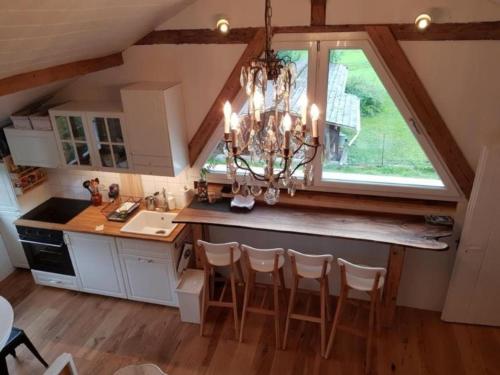 a kitchen with a chandelier and a large window at Studio Chic mit Whirlpool in Wildhaus
