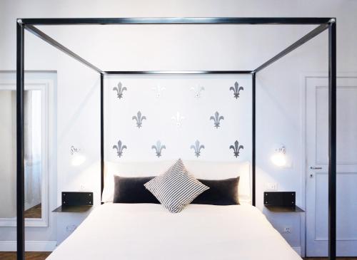 uma cama de dossel preta com almofadas pretas e brancas em Domus 19 em Florença