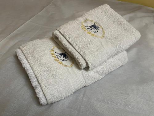 two white towels sitting on top of a bed at Hotel Lupus in Novi Sad