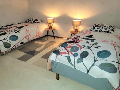 two beds in a room with two lamps on tables at Best possible location, 1 bedroom apartment in Närpiö