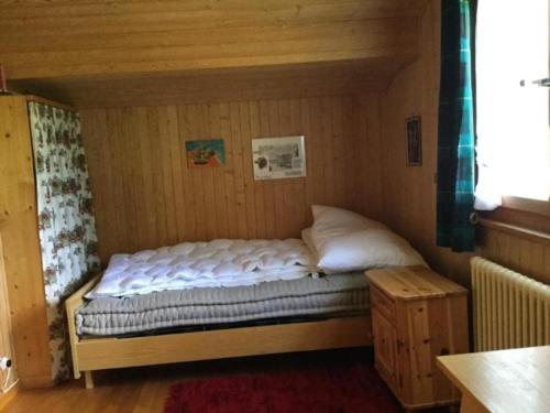 a small bed in a small room with at Chalet mit grossem Umschwung in Cerniat