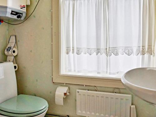 La salle de bains est pourvue de toilettes, d'un lavabo et d'une fenêtre. dans l'établissement Holiday home GRISSLEHAMN VIII, à Grisslehamn