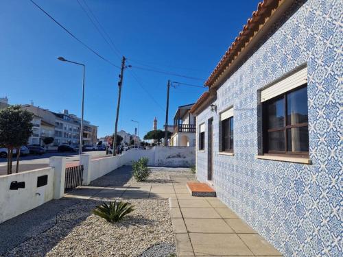 um edifício azul e branco com uma janela e um passeio em Casa do Conde Praia da Barra em Gafanha da Nazaré