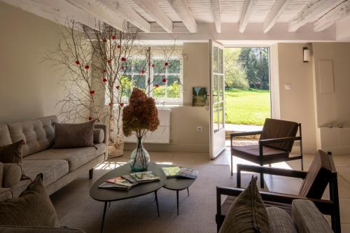 uma sala de estar com um sofá e uma mesa em Moulin de Vilgris em Clairefontaine