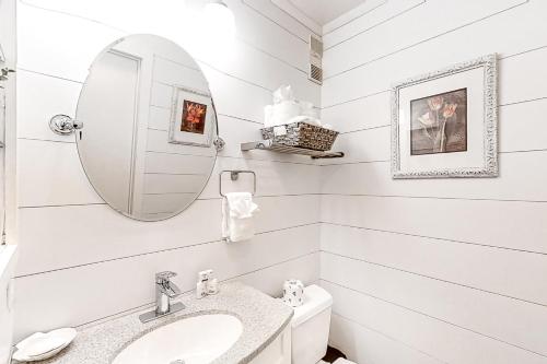 a white bathroom with a sink and a mirror at Beach Trees Lodge in Myrtle Beach