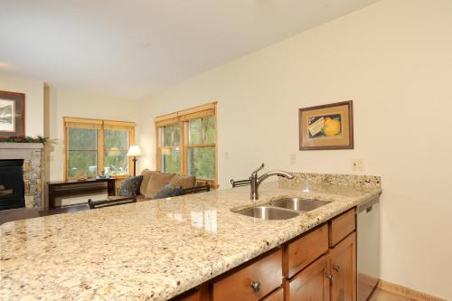 a kitchen with a sink and a living room at Jackpine & Black Bear Condominiums by Keystone Resort in Keystone