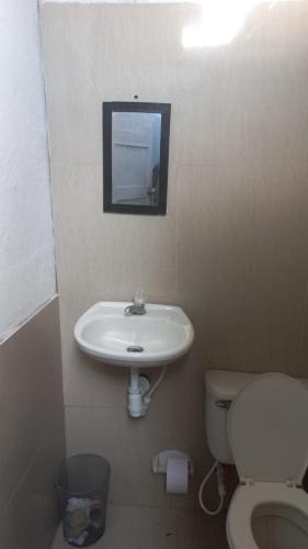 y baño con lavabo, aseo y espejo. en apartamento Monimar en TAGANGA en Santa Marta