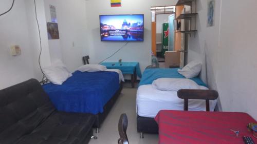 Habitación con 2 camas, sofá y TV. en apartamento Monimar en TAGANGA, en Santa Marta