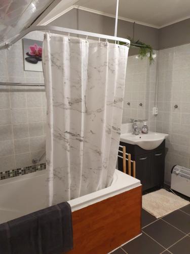 a bathroom with a white shower curtain and a sink at Ferienwohnung am Siegelbächle mit E-Bikes Vermietung in Gutach im Breisgau