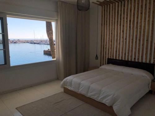 1 dormitorio con cama y ventana grande en Apartamento primera línea Puerto Banus con vistas, en Marbella